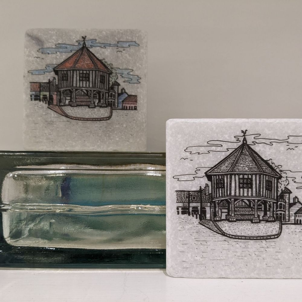 Two handmade ceramic tiles featuring illustrated market hall buildings with fine architectural linework.