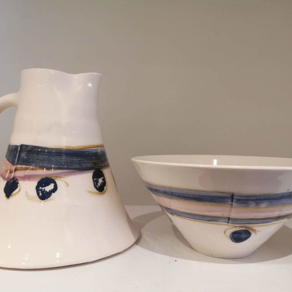 Handmade white ceramic jug and bowl set with blue, pink and dark circular glazed detailing.