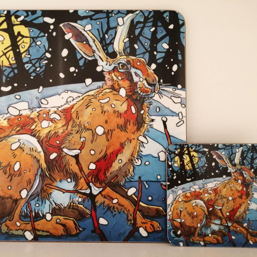 Matching placemat and coaster set featuring an illustrated hare sitting in a snowy woodland scene.