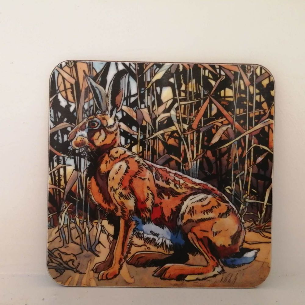 Square coaster featuring a colourful illustrated hare sitting among reeds and woodland plants.
