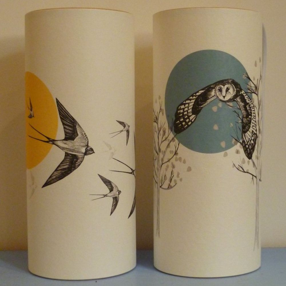Two cylindrical lamps featuring nature-inspired illustrations of swallows and an owl.