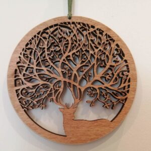 Wooden hanging decoration featuring an intricate cut-out tree of life design inside a circular frame.