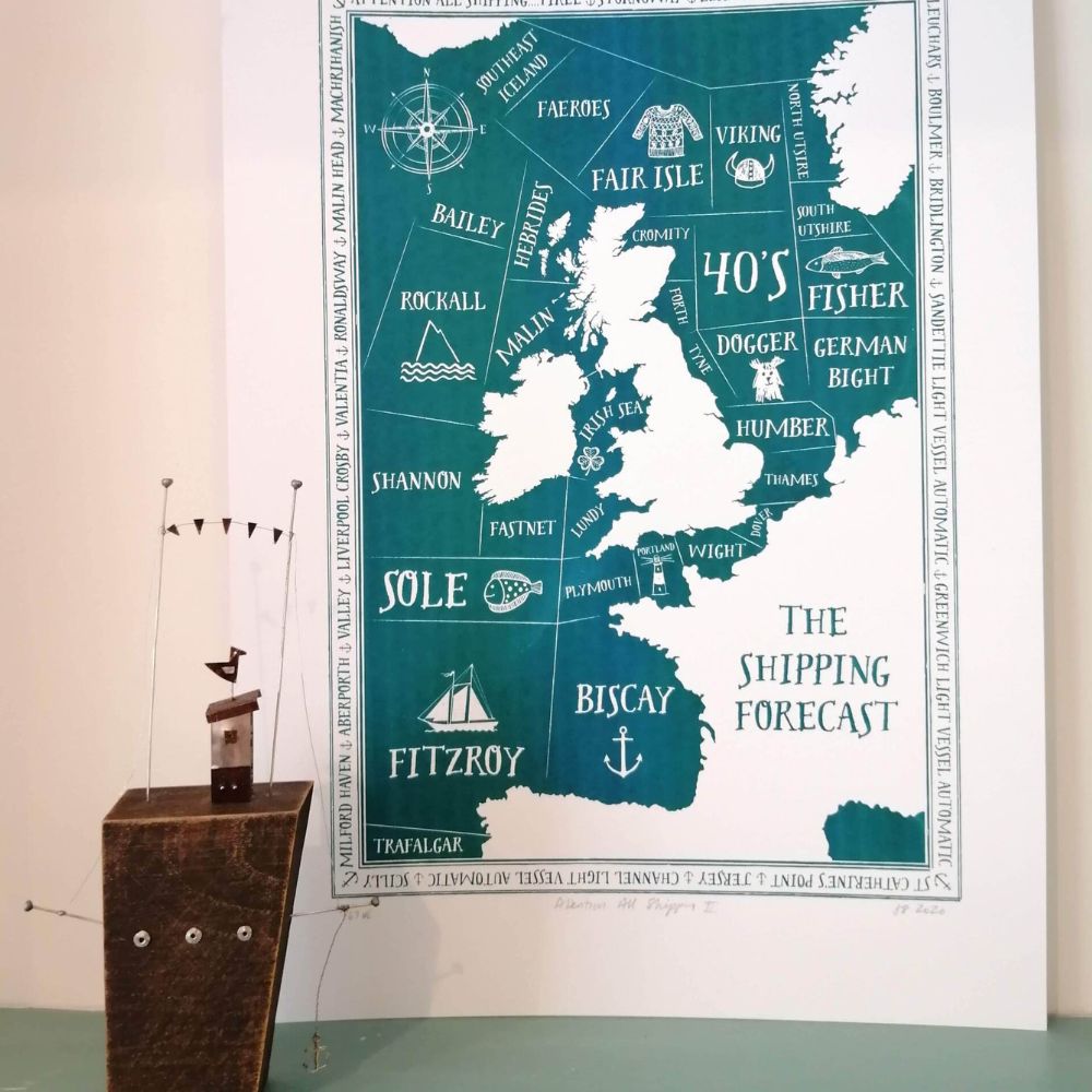 Teal and white art print showing a map of the UK shipping forecast areas, displayed beside a small wooden boat ornament.